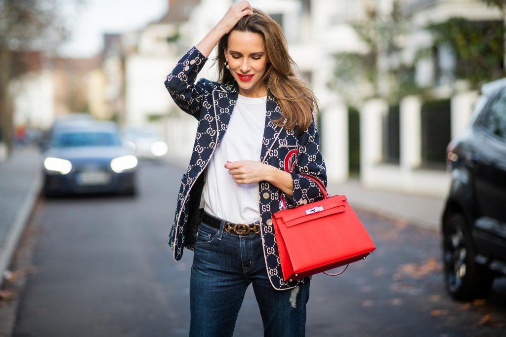 college look, Gucci, AG Denim, Adriano Goldschmied, Gucci loafers, Falke, Dior, The Frankie Shop, Hermes, Kelly bag DUESSELDORF, GERMANY - DECEMBER 11: Alexandra Lapp is seen wearing a college look, dark denim blue jeans AG Jeans, white sleeveless muscle tshirt with padded shoulders The Frankie Shop, Gucci GG horsebit leather belt, Gucci college jacket with logo print, red Hermes Kelly bag on December 11, 2019 in Duesseldorf, Germany. (Photo by Christian Vierig/Getty Images)