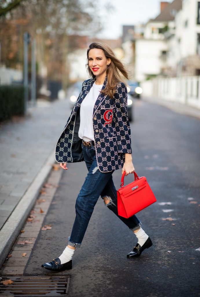 college look, Gucci, AG Denim, Adriano Goldschmied, Gucci loafers, Falke, Dior, The Frankie Shop, Hermes, Kelly bag DUESSELDORF, GERMANY - DECEMBER 11: Alexandra Lapp is seen wearing a college look, dark denim blue jeans AG Jeans, white sleeveless muscle tshirt with padded shoulders The Frankie Shop, Gucci GG horsebit leather belt, Gucci college jacket with logo print, red Hermes Kelly bag on December 11, 2019 in Duesseldorf, Germany. (Photo by Christian Vierig/Getty Images)