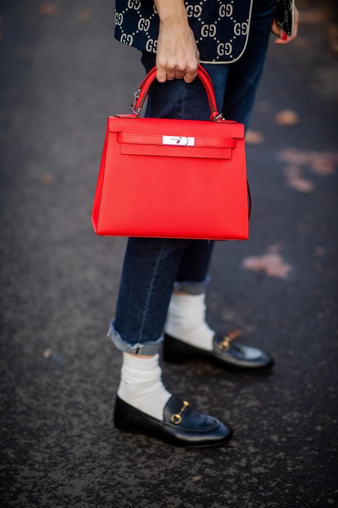 college look, Gucci, AG Denim, Adriano Goldschmied, Gucci loafers, Falke, Dior, The Frankie Shop, Hermes, Kelly bag DUESSELDORF, GERMANY - DECEMBER 11: Alexandra Lapp is seen wearing a college look, dark denim blue jeans AG Jeans, white sleeveless muscle tshirt with padded shoulders The Frankie Shop, Gucci GG horsebit leather belt, Gucci college jacket with logo print, red Hermes Kelly bag on December 11, 2019 in Duesseldorf, Germany. (Photo by Christian Vierig/Getty Images)