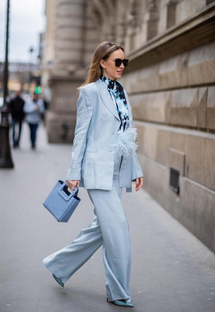 PARIS, FRANCE - FEBRUARY 25: Alexandra Lapp is seen wearing a suit style, light blue De La Vali suit, blue Shirley mini bag from Staud, 16Arlington satin top with feathers, Prada pumps in light blue, square-frame black Bottega Veneta sunglasses all from Net-A-Porter during Paris Fashion Week - Womenswear Fall/Winter 2020/2021 : Day Two on February 25, 2020 in Paris, France.