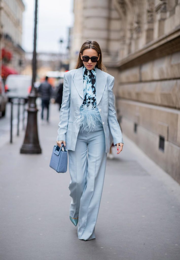 PARIS, FRANCE - FEBRUARY 25: Alexandra Lapp is seen wearing a suit style, light blue De La Vali suit, blue Shirley mini bag from Staud, 16Arlington satin top with feathers, Prada pumps in light blue, square-frame black Bottega Veneta sunglasses all from Net-A-Porter during Paris Fashion Week - Womenswear Fall/Winter 2020/2021 : Day Two on February 25, 2020 in Paris, France.