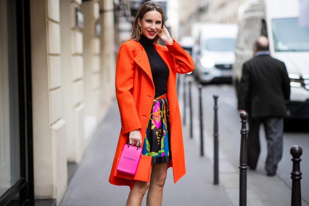 Alexandra Lapp, Givenchy, Versace, Dorothee Schumacher, slingback pumps, The Attico, Balenciaga, Medea, Paris Fashion Week, Womenswear Fall/Winter 2020/2021 PARIS, FRANCE - FEBRUARY 26: Alexandra Lapp is seen wearing a Givenchy coat in orange, pleated silk skirt from Versace, turtleneck pullover in black from Dorothee Schumacher, slingback pumps in orange from The Attico, Balenciaga Tote Shopping Phone bag, Medea Vinile Short bag during Paris Fashion Week - Womenswear Fall/Winter 2020/2021 : Day Three on February 26, 2020 in Paris, France.