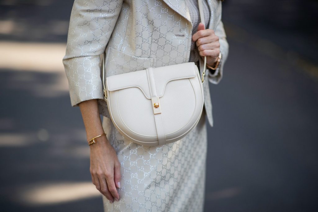 Alexandra Lapp is seen wearing Gucci monogram lamé jacket in off-white and silver, IRIS von ARNIM short cashmere sweater in alabaster, Gucci monogram lamé skirt in off-white and silver, CELINE Besace 16 bag in cream and AQUAZZURA Gainsbourg suede autumn boots in light grey. All looks by Breuninger.