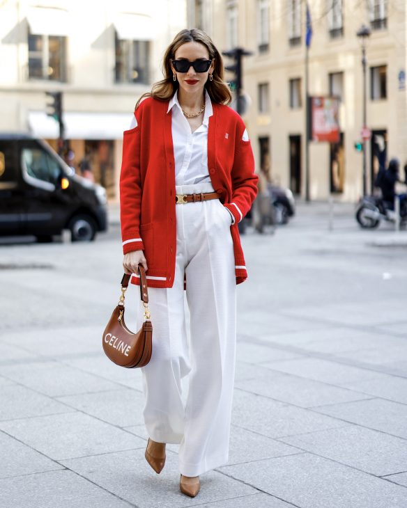 Alexandra Lapp is seen wearing colorful looks during Paris Fashion week by GIVENCHY cut-out shoulder cardigan in red, JIL SANDER blouse in white, MAX MARA wide legged pants in creme, CELINE belt in cognac, CELINE Ava strap bag in cognac, CELINE sunglasses, and CHRISTIAN LOUBOUTIN So Kate pumps in cognac. Total look via La Boutique Conceptstore, Dresden.