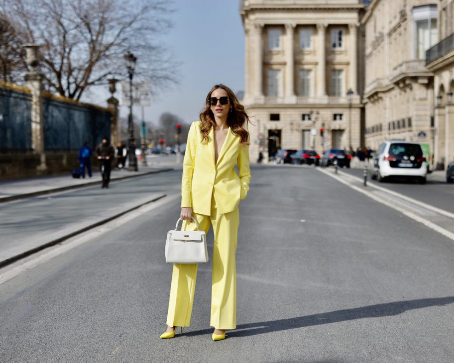 Alexandra Lapp is seen wearing colorful looks during Paris Fashion Week. COMMA blazer and trousers in yellow, Chanel flap bag in white, CHRISTIAN LOUBOUTIN Hot Chick pumps in yellow, and FOR ART’S SAKE sunglasses in brown.